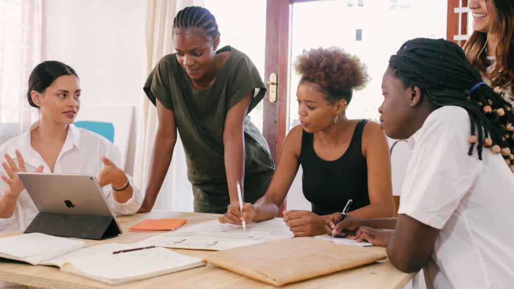 Procurement team sitting around a desk collaborating on the intake process
