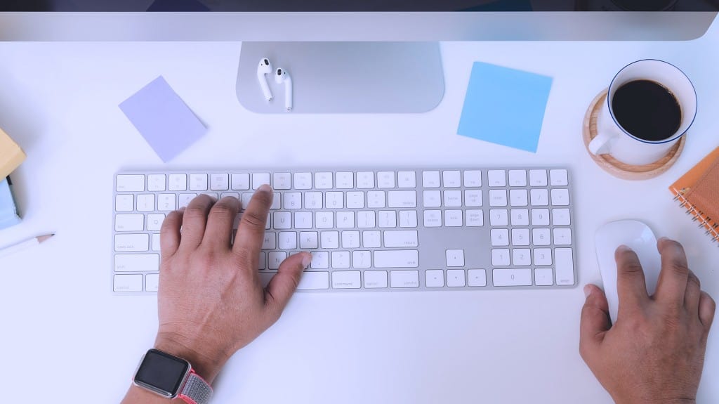 Person typing on keyboard while working remote