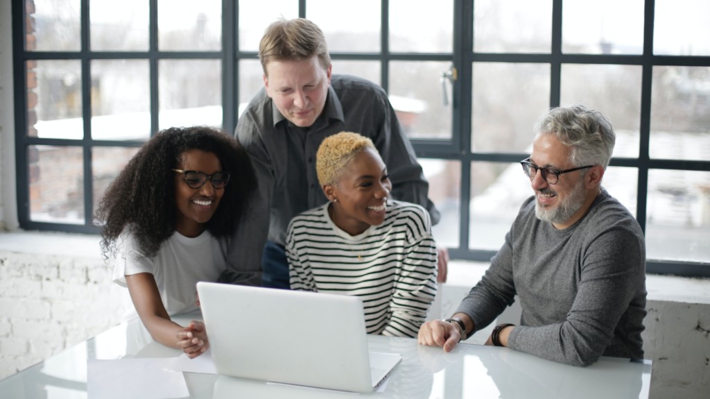 Multi-generational procurement team collaborating with technology